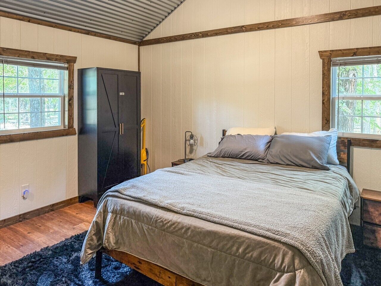 Quarto com cama, guarda-roupa e janela.