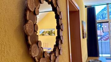 A circular mirror with a wooden frame on a yellow wall.