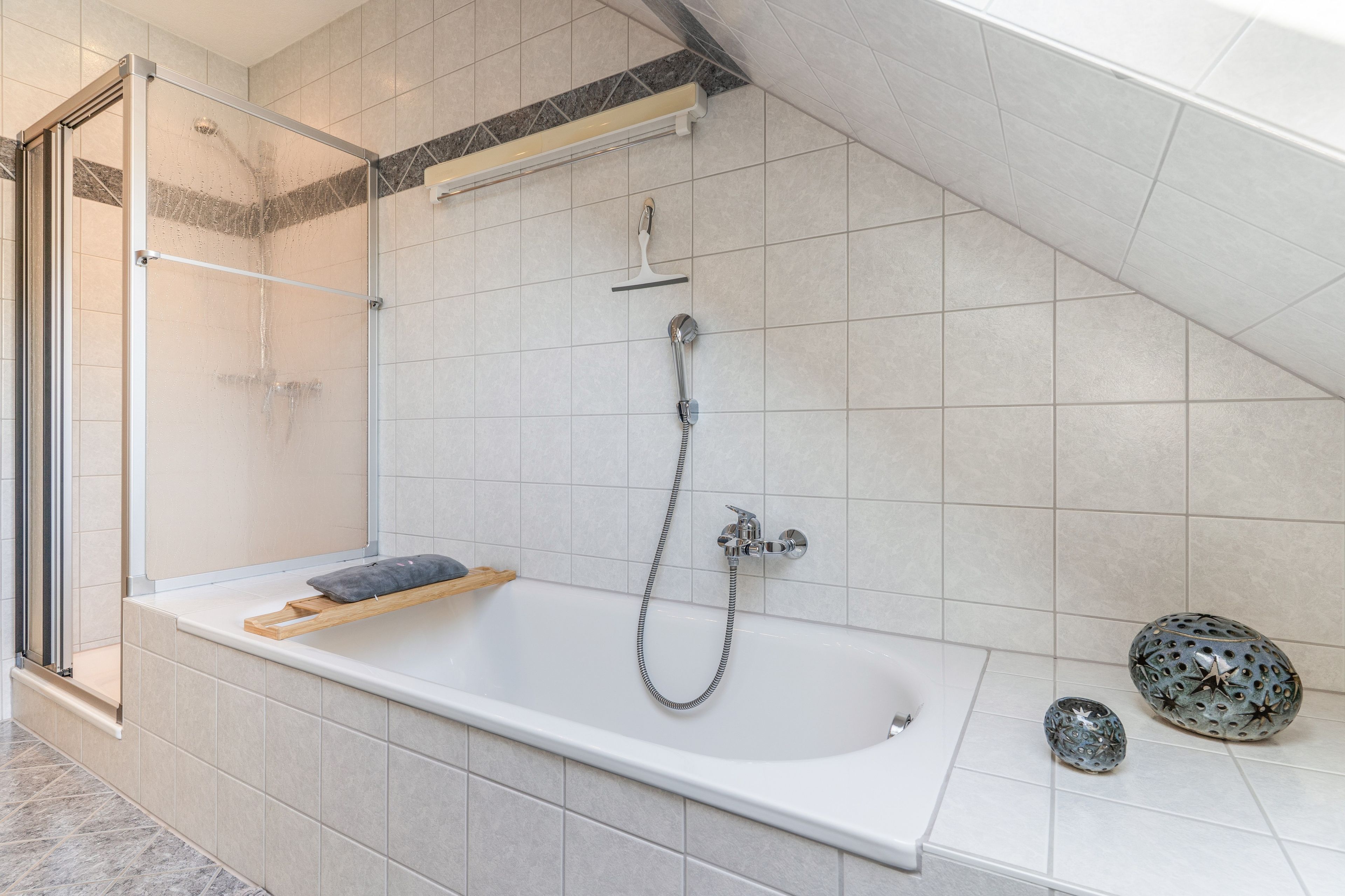 Un baño moderno con una bañera independiente, un cabezal de ducha y un perchero para toallas.