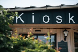 Un escaparate con el letrero 'Kiosk' y una pizarra con el menú.