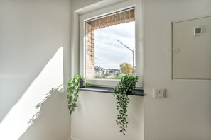 Une pièce avec une fenêtre, un mur en briques et un thermostat.