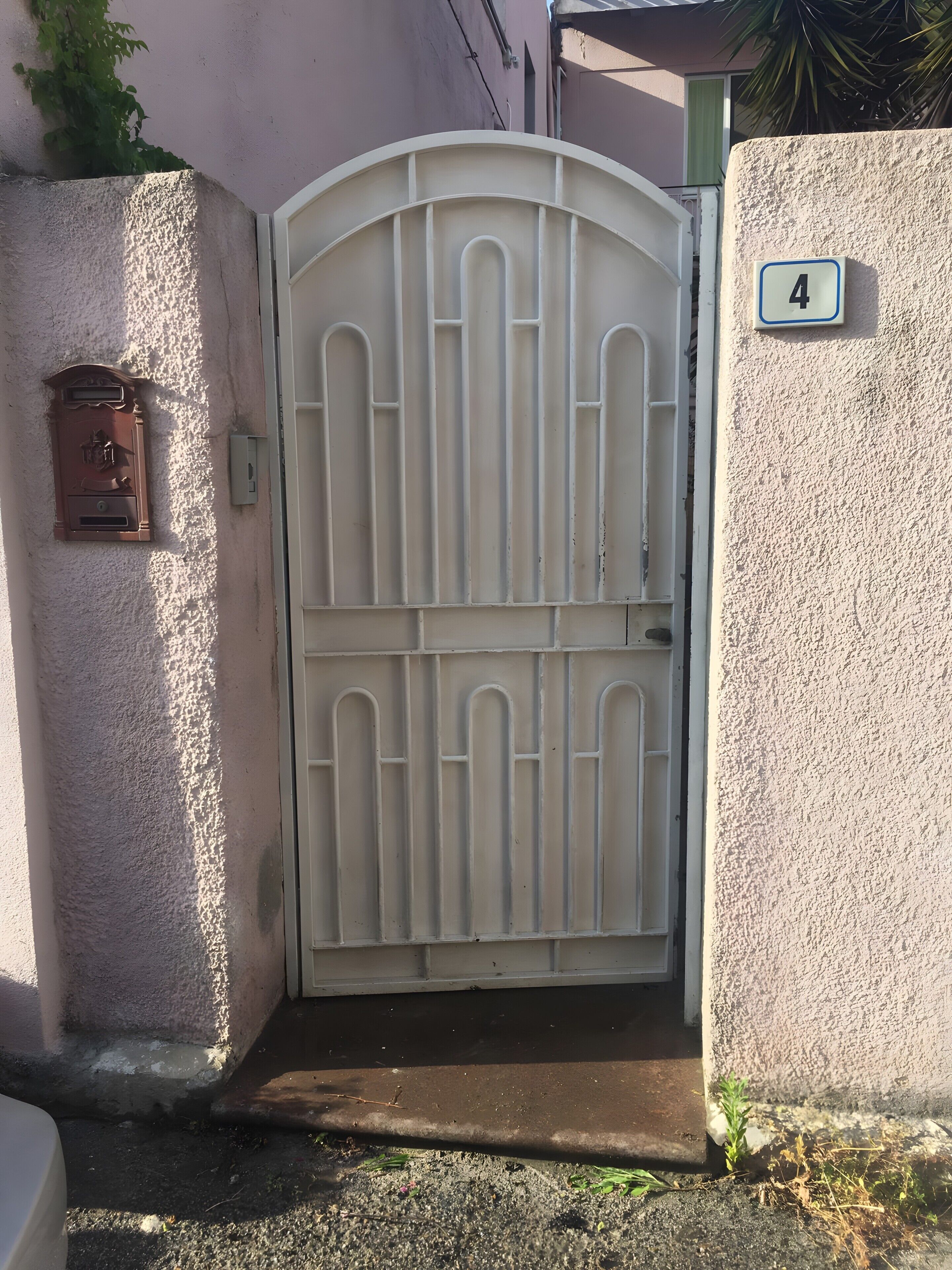 Portilla on numero, postilaatikko ja pieni kasvi.
