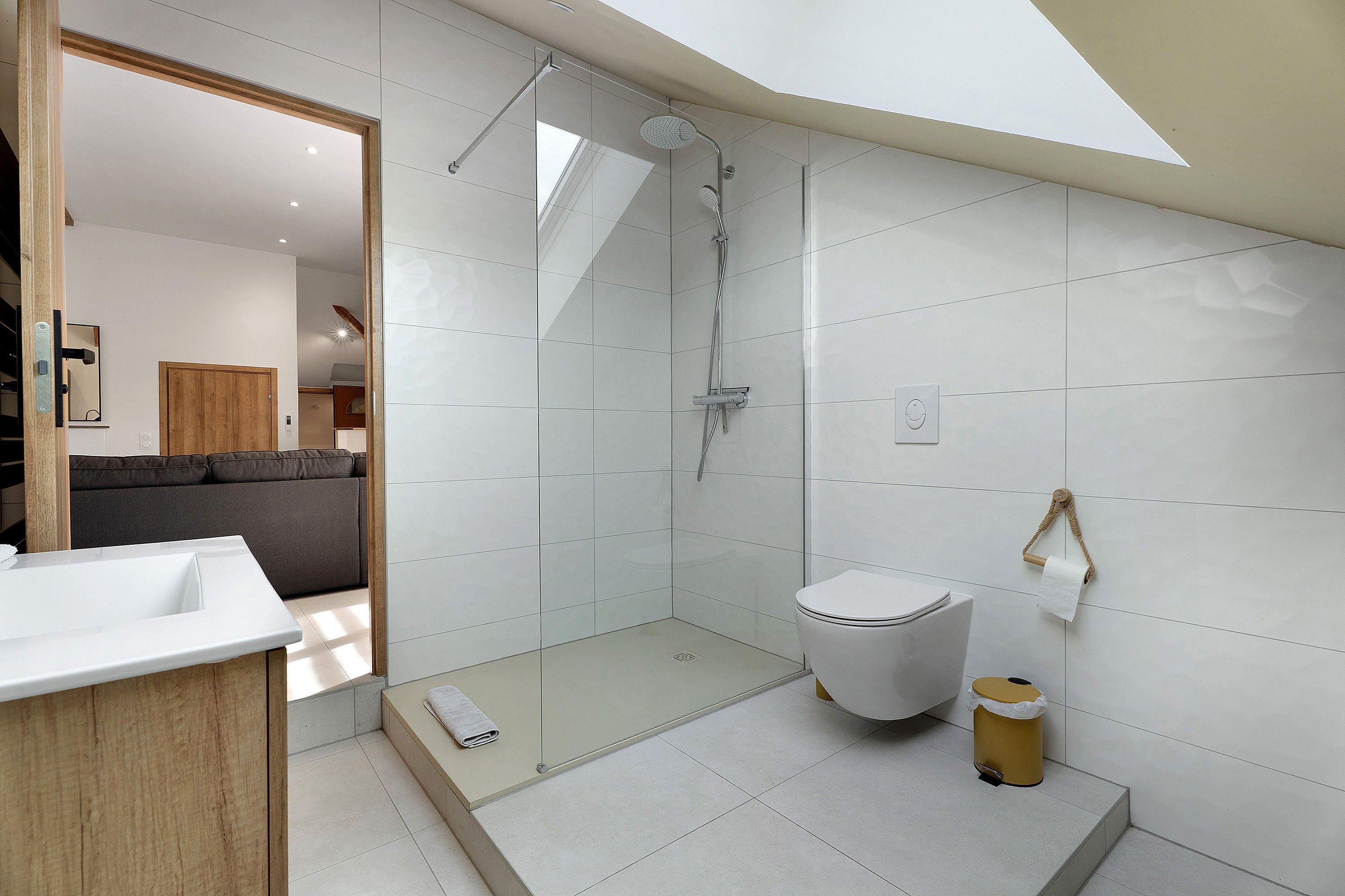 A modern bathroom with a glass shower enclosure, a toilet, and a sink.