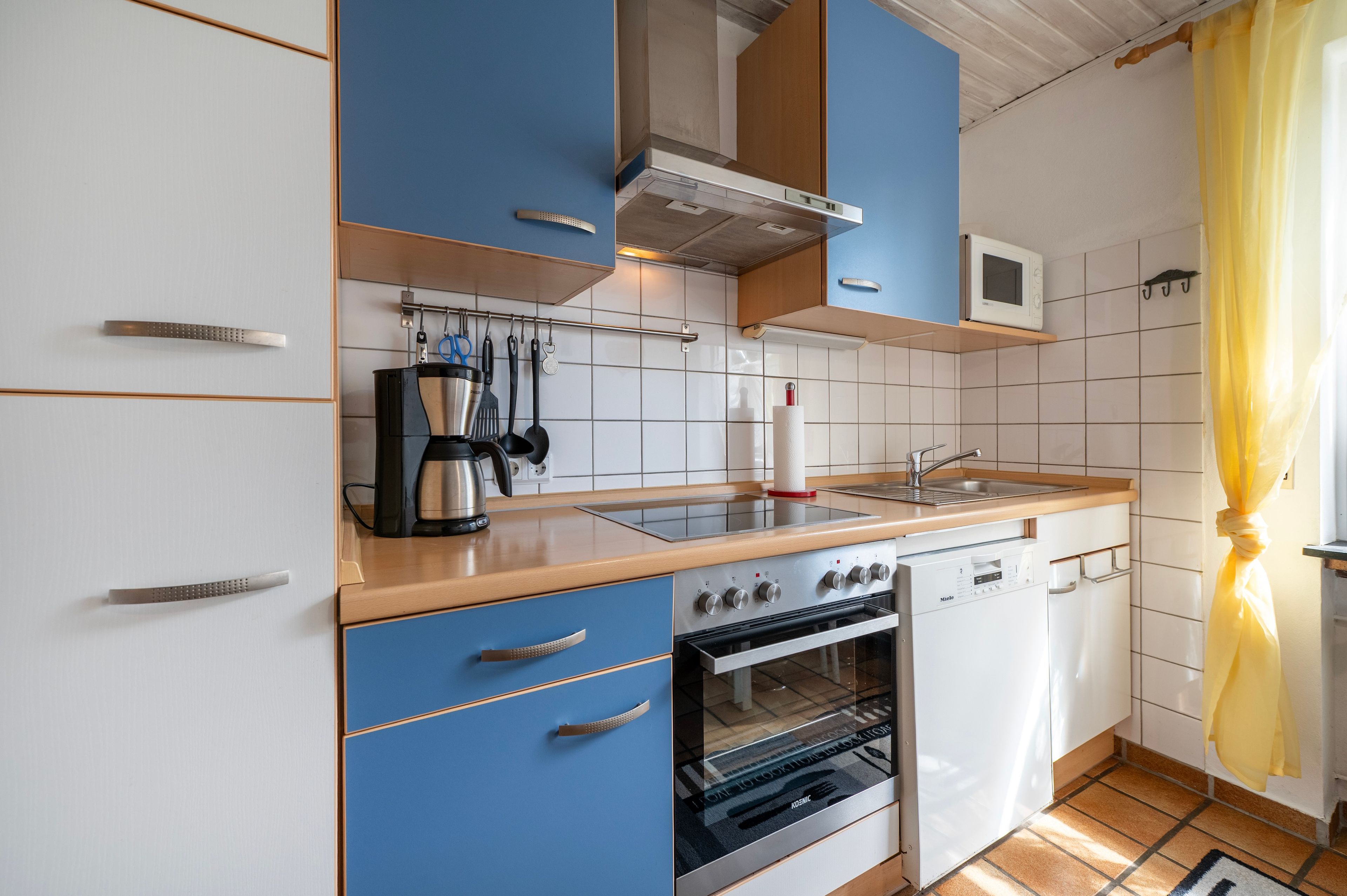 Een moderne keuken met een inbouwoven, een magnetron en een koffiezetapparaat.