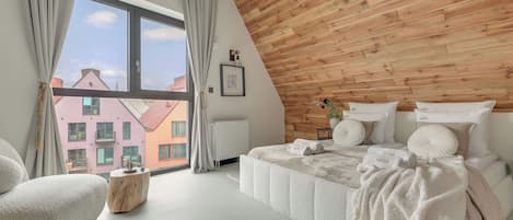 Un dormitorio moderno con un ventanal grande, una pared de madera y una cama bien hecha.