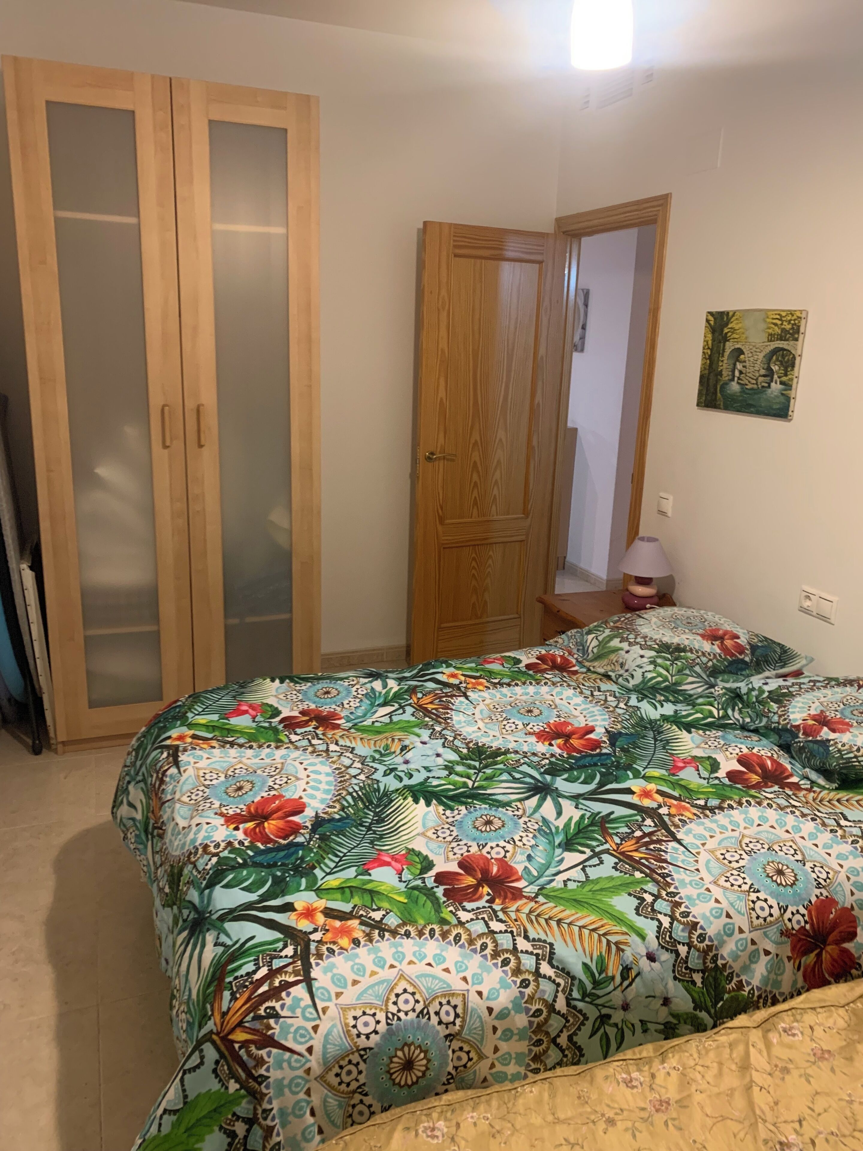 A bedroom with a bed, a wardrobe, and a door.