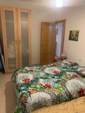 A bedroom with a bed, a wardrobe, and a door.