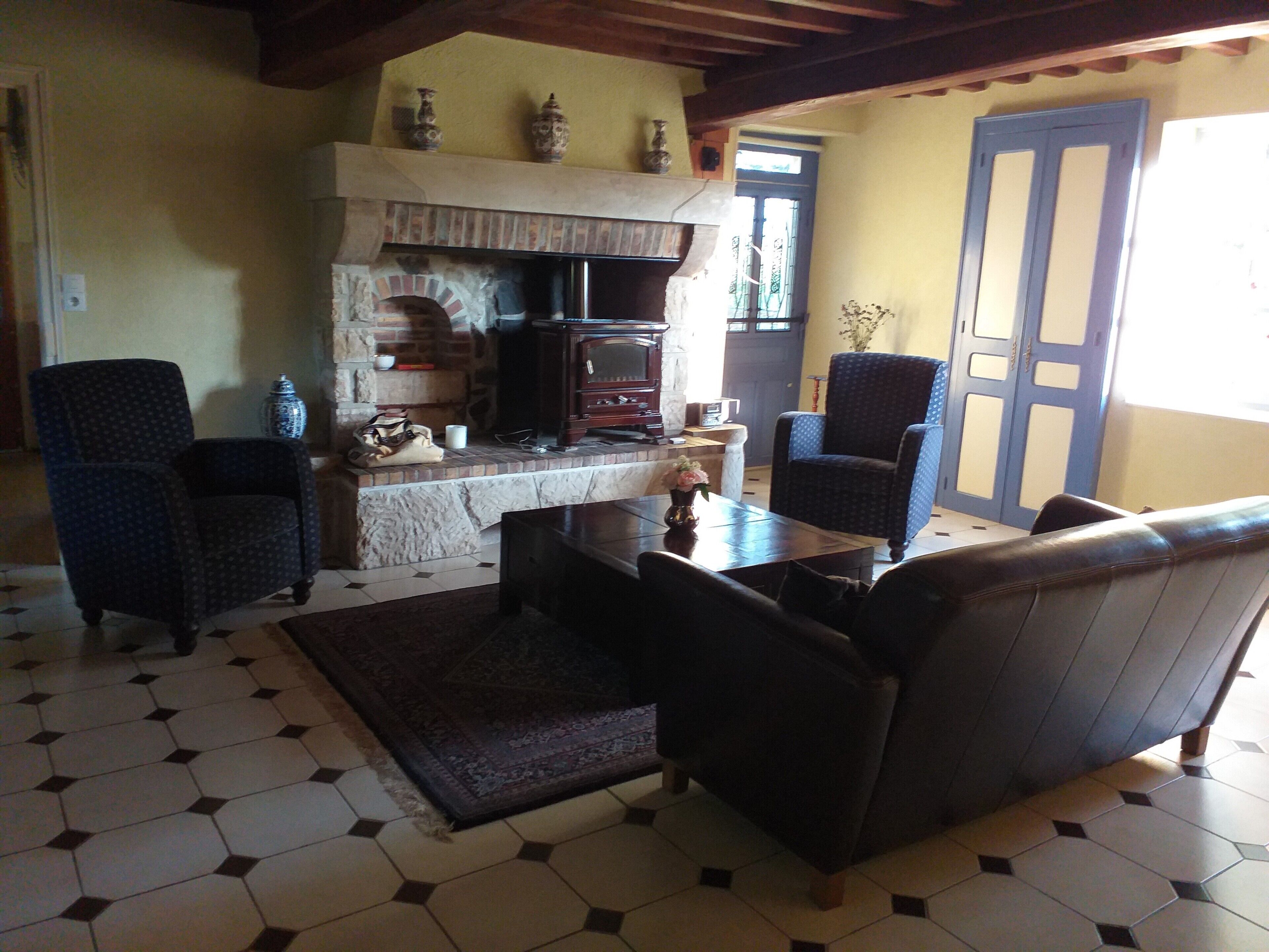 A living room with a fireplace, two armchairs, a sofa, and a coffee table.