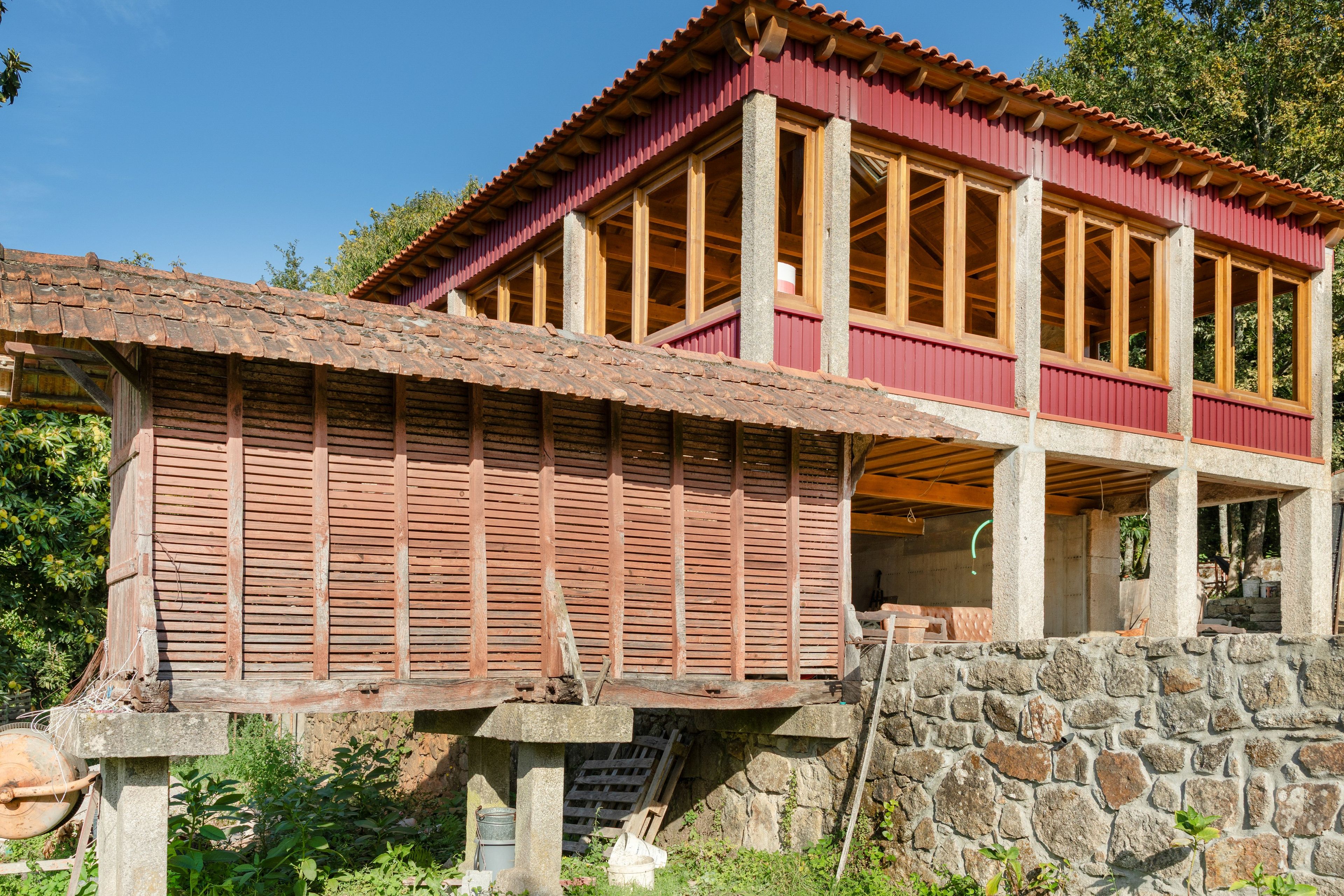Un edificio de dos pisos con fachada roja y vigas de madera.