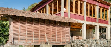 Un edificio de dos pisos con fachada roja y vigas de madera.