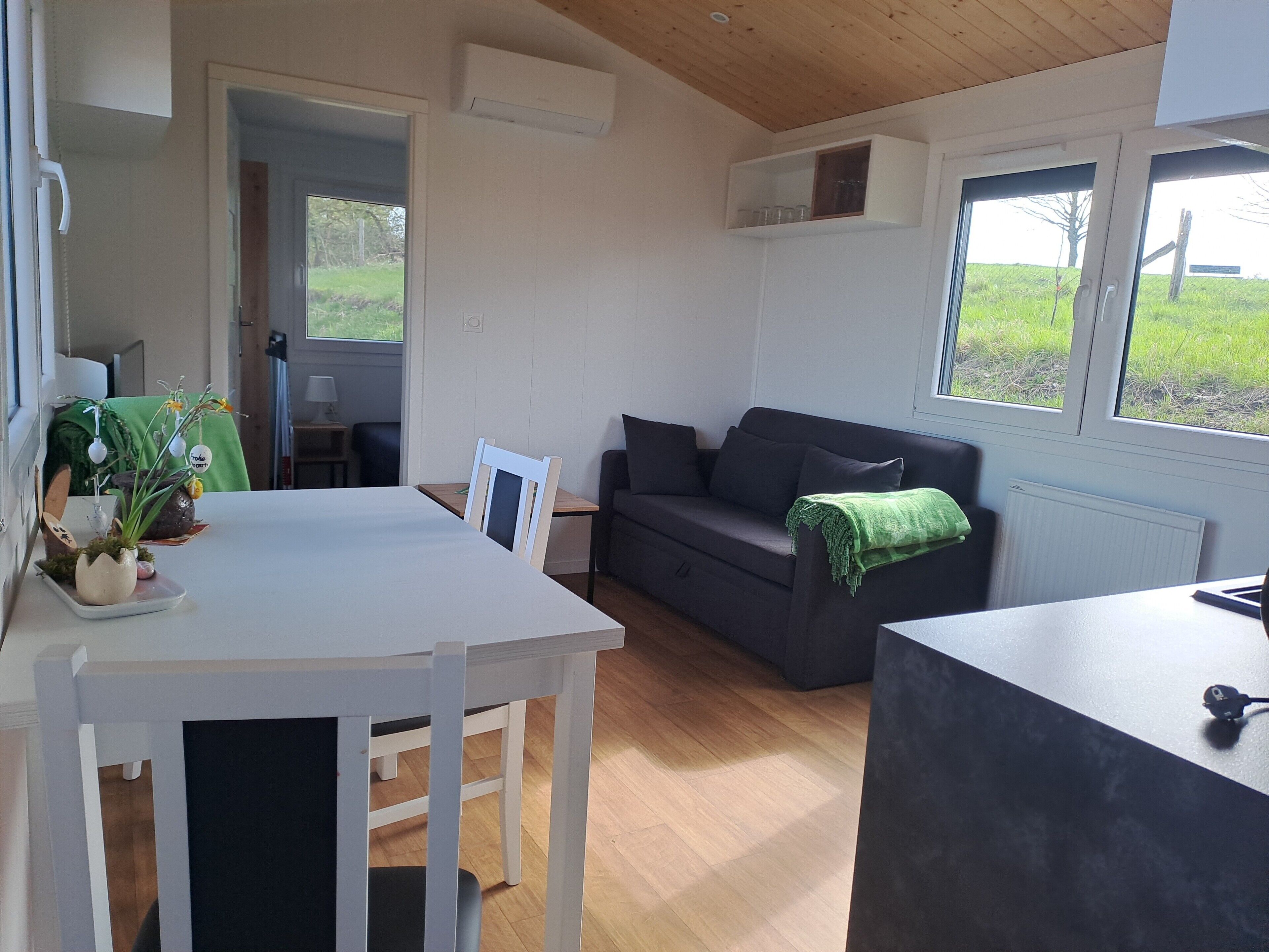 Una sala de estar moderna con un sofá, una mesa de comedor y una zona de cocina.
