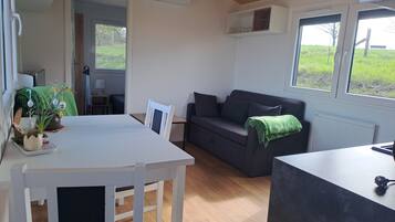 Una sala de estar moderna con un sofá, una mesa de comedor y una zona de cocina.
