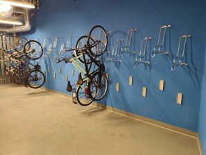 A bike parking area with multiple bicycles secured to wall-mounted racks. - LILY ART by Lily Apart (Gdańsk)