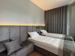 A hotel room with a sofa and two single beds. - LILY ART by Lily Apart (Gdańsk)