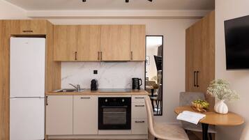 A modern kitchen with wooden cabinets, a built-in oven, and a dining area with a table and chairs.