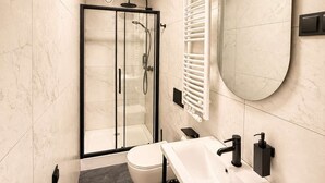 A modern bathroom with a glass shower enclosure, a white sink, and a large mirror. - Kraków Bohaterów Września 8 | AC | Parkside (Kraków)