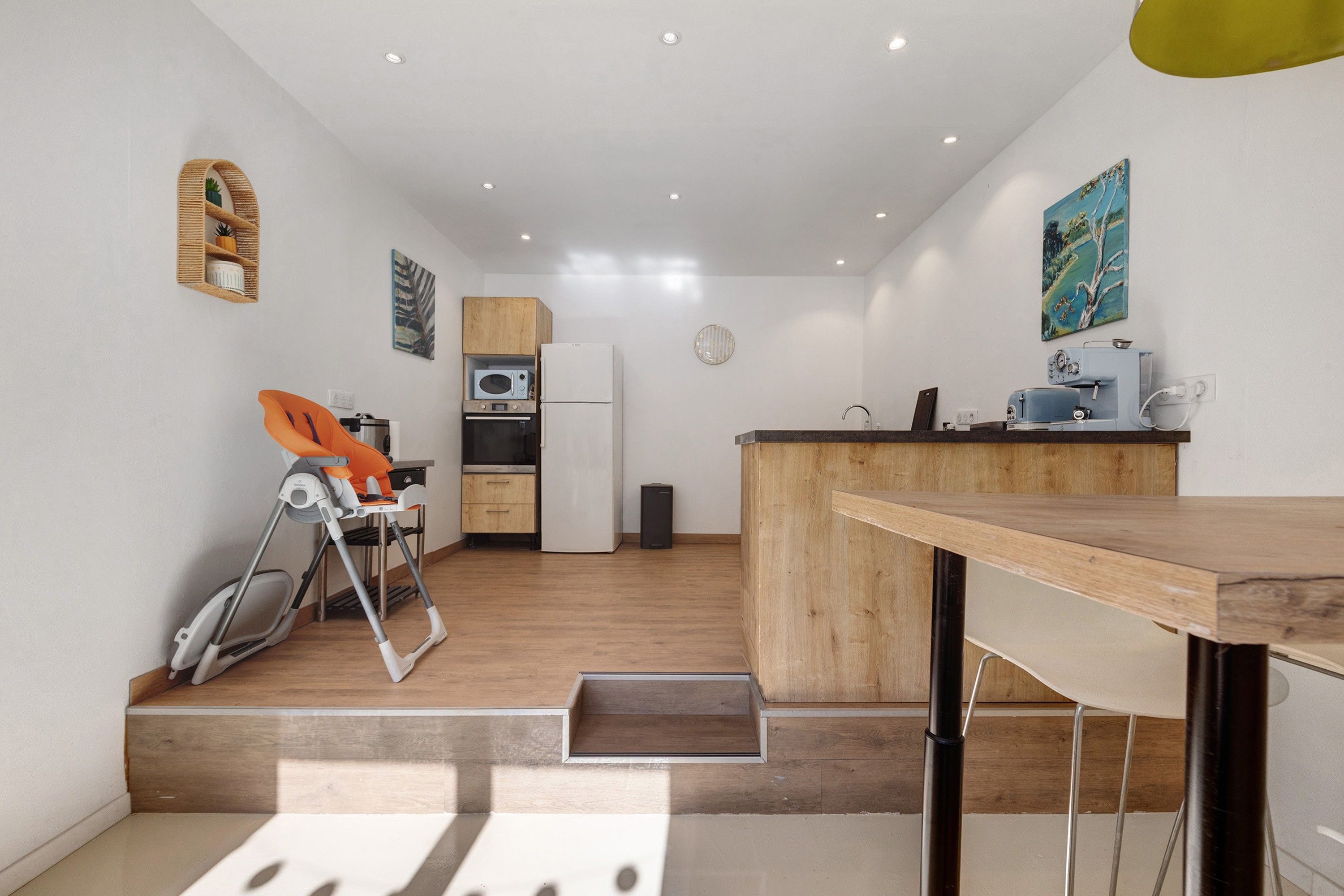 Una cocina compacta con microondas, refrigerador y armarios de madera.