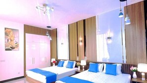 A modern hotel room with two beds, a large mirror, and a wooden wardrobe.