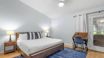 Ein Schlafzimmer mit einem Bett, Nachttischen, einem Schreibtisch und einem Stuhl.