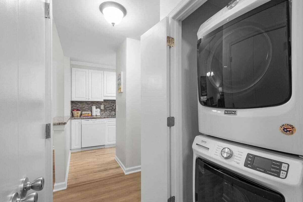 A kitchen with white cabinets, a countertop with various items, and a built-in oven.