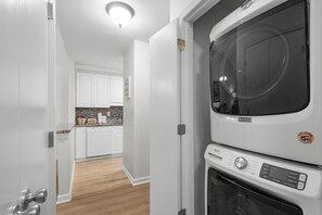 A kitchen with white cabinets, a countertop with various items, and a built-in oven. - Fairway Serenity at River Club (Pawleys Island)