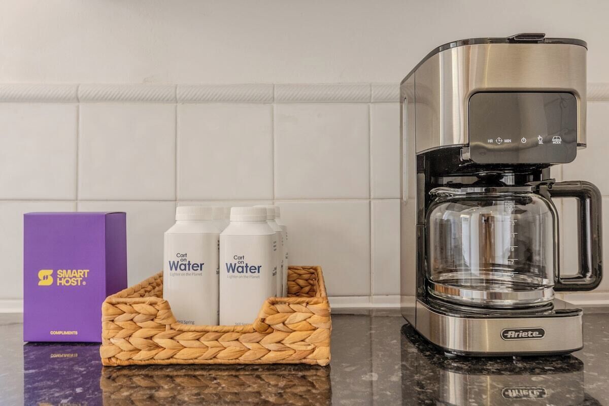 Una cocina con cafetera, dos botellas de agua y una caja morada que dice 'SMART HOST'.