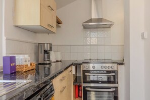 Eine Küche mit einem Doppelbackofen, einer Kaffeemaschine und einem Wasserspender.