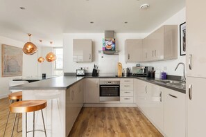 A modern kitchen with a central island, stainless steel appliances, and pendant lighting. - New! Modern 3BR w/Balcony | Hoxton & Shoreditch (Greater London)