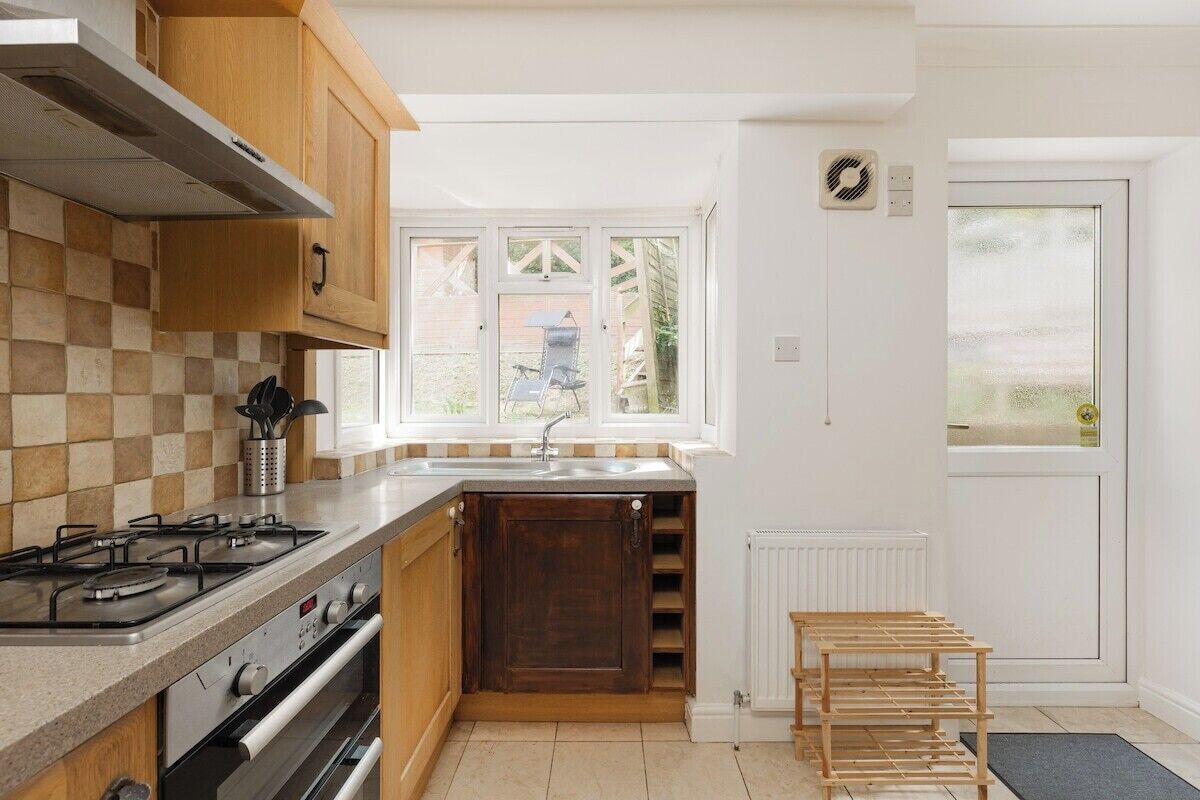 A kitchen with a gas stove, oven, and a window with a view of the outside.
