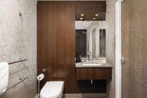 A modern bathroom with a wooden vanity, a toilet, and a shower area. - New! Charming 1BR Flat | Fulham & Chelsea (Greater London)