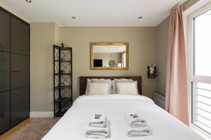 A bedroom with a bed, a mirror, a wardrobe, and a shelf. - New! Charming 1BR Flat | Fulham & Chelsea (Greater London)