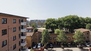 Ein mehrgeschossiges Wohngebäude mit Balkonen, einem Parkplatz und Bäumen.
