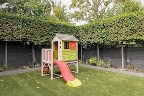 A children's playhouse with a slide in a backyard. - New! Spacious 3BR | Garden & Parking | Willesden (Greater London)