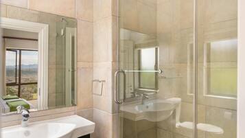 A modern bathroom with a glass-enclosed shower, a sink, and a mirror.