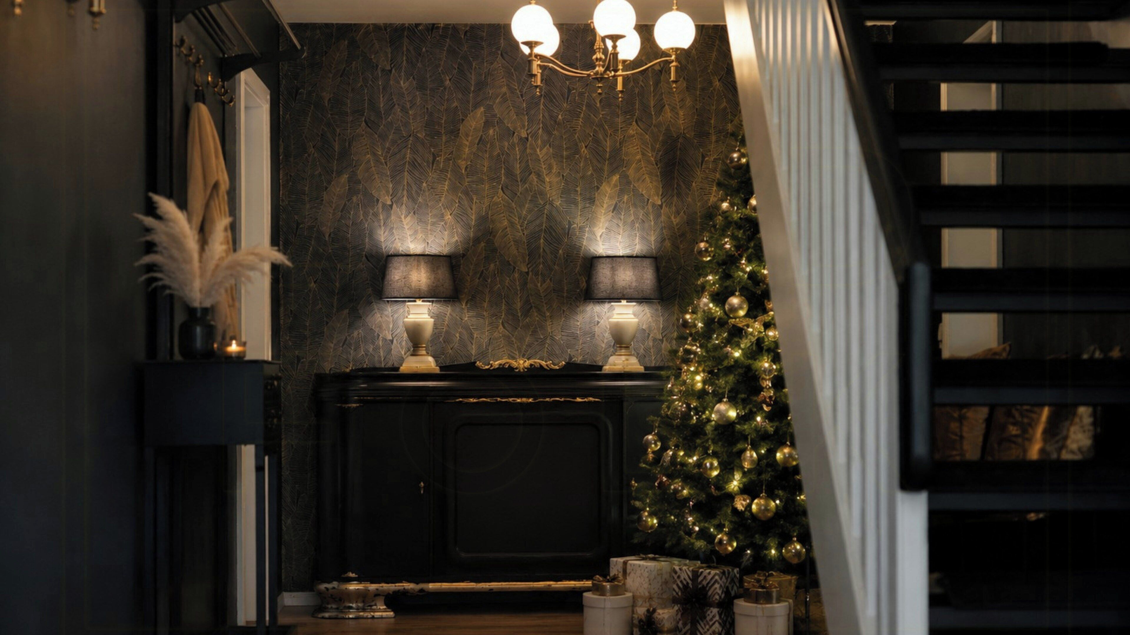 Een donker interieur met een open haard, twee lampen, een kerstboom en een trap.