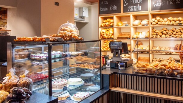 A bakery display with various baked goods and a cash register. - 1628 Aurora Studio ohne Balkon by Interhome (Lenzerheide)