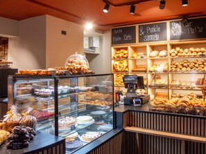 A bakery display with various baked goods and a cash register. - Apartment  by Interhome (Lenzerheide)