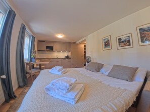 Ein Hotelzimmer mit Bett, Schreibtisch und einer Küchenzeile.