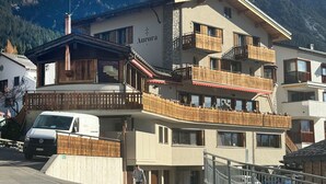 A multi-story hotel with balconies, a sign reading 'Aurora,' and a mountainous backdrop. - 1628 Aurora Studio ohne Balkon by Interhome (Lenzerheide)
