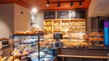 Mostrador de una panadería con diversos productos horneados y una caja registradora.