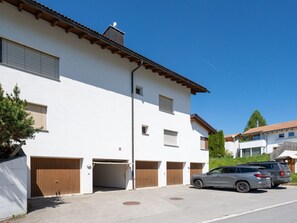 Ein modernes, zweistöckiges Gebäude mit Garage, Auffahrt und einem abgestellten SUV.