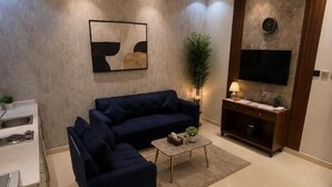 Una sala de estar moderna con un sofá, una mesa de centro y un televisor de pantalla plana montado en la pared.