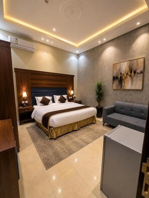 A modern hotel room with a large bed, bedside tables, a sofa, and a painting on the wall. - lyaly aknan for served apartment branch2 (abha)