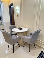 Un comedor moderno con una mesa redonda y dos sillas grises tapizadas.