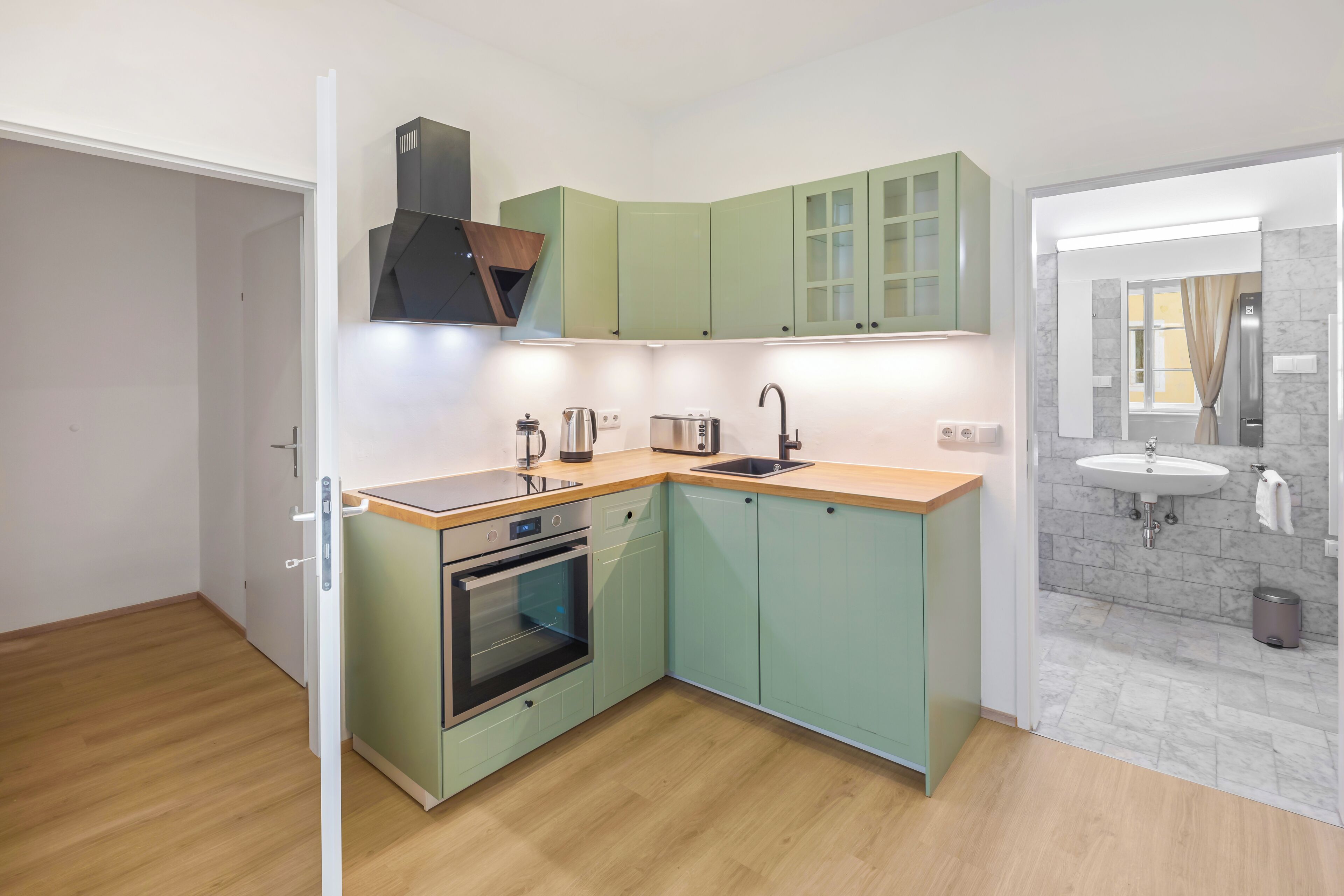 A compact kitchen with a built-in oven, a sink, and a microwave.
