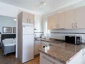 A modern kitchen with a built-in oven, microwave, and dishwasher. - Los Naranjos 11B Capistrano Village by Casasol by Interhome (Nerja)
