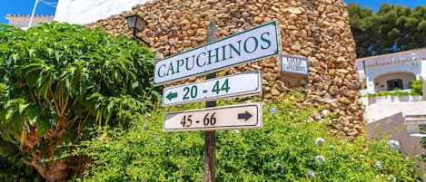 Una señal de calle indica Capuchinos con flechas direccionales hacia las calles 20-44 y 45-66.