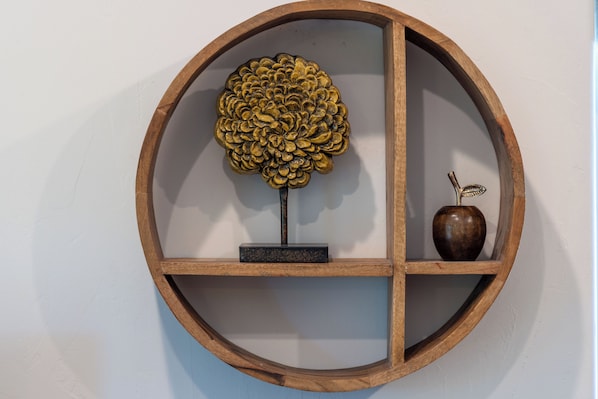A circular wooden shelf with a decorative tree and an apple.