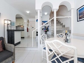 A modern interior with a dining area, kitchen, and staircase. - Los Pinos 29 Villas by Casasol by Interhome (Nerja)