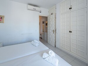 A hotel room with a bed, a bathroom, and a wardrobe. - Los Pinos 29 Villas by Casasol by Interhome (Nerja)